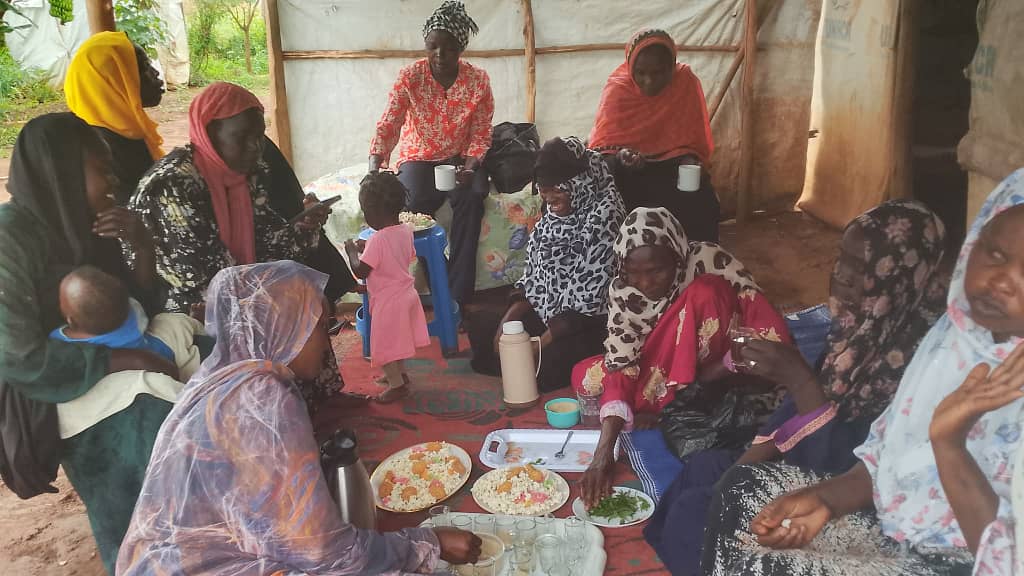 Mothers and children sharing a meal in a shelter