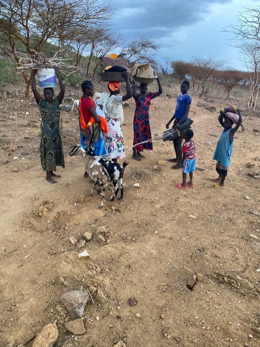 Mothers and children carrying their belongings